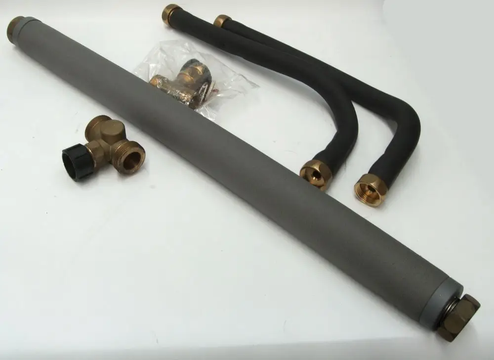 Daikin Zubehörset bestehend aus grauem Rohr und zwei schwarzen Schläuchen mit messingfarbenen Anschlüssen sowie einem Verbindungsstück.